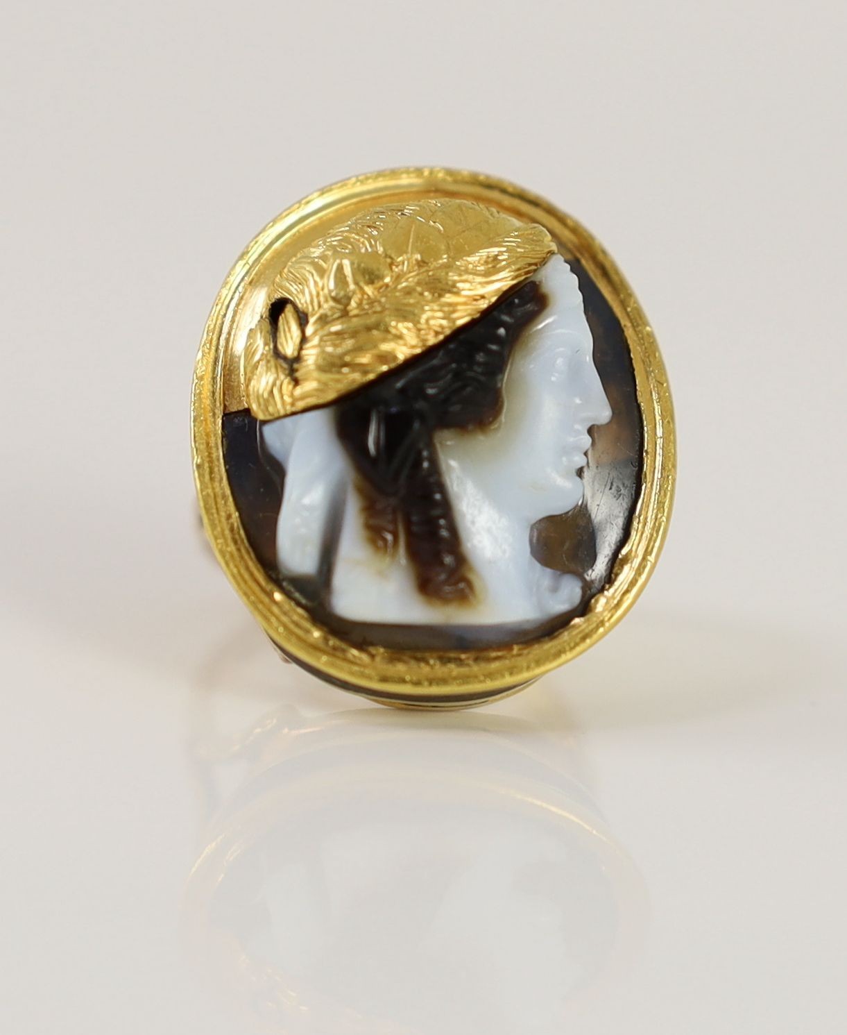 An antique gold mounted sardonyx cameo, possibly carved with the head of a Alexander The Great to sinister, now in later 9ct gold ring mount